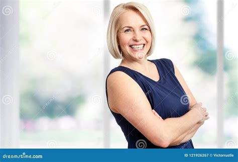attractive middle aged woman with a beautiful smile near the window stock image image of lady