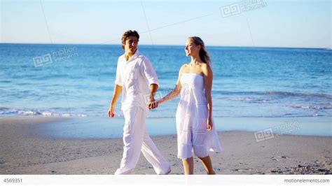 Couple Holding Hands While Walking Along The Beach Stock Video Footage 4569351