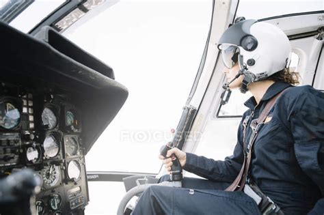 Focused Female Pilot Sitting And Operating In Helicopter — Flight