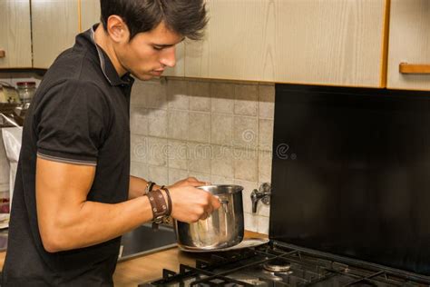 hombre joven que cocina la comida en estufa foto de archivo imagen de lifestyle doméstico