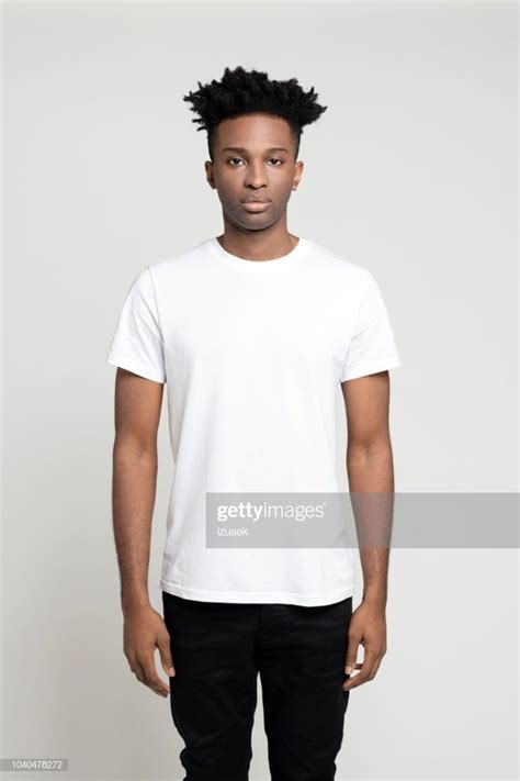 Studio Portrait Of Serious Young Afro American Man Standing On White