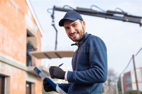 Man Outside Property Development Writing On Clipboard Stock Photo