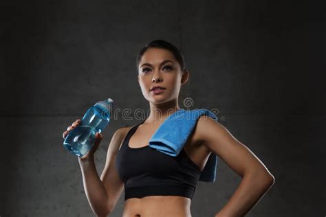 Woman With Towel Drinking Water From Bottle In Gym Stock Photo Image