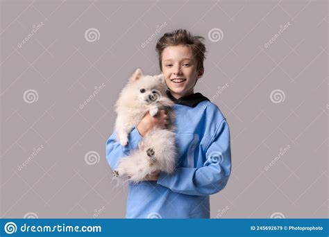 Caucasian Happy Teen Boy Hugging Spitz Dog Guy Is Standing In Sports