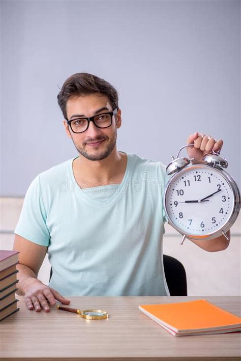 Young Male Student In Time Management Concept In The Classroom Stock