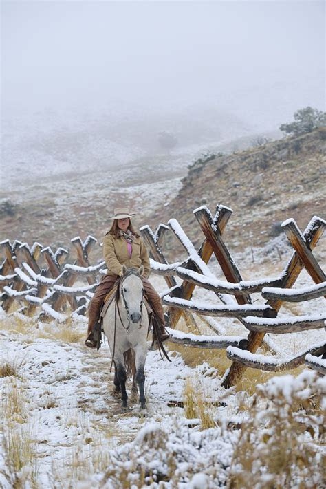 Cowgirl Riding Horse Beside Fence In Snow Rocky Mountains Wyoming