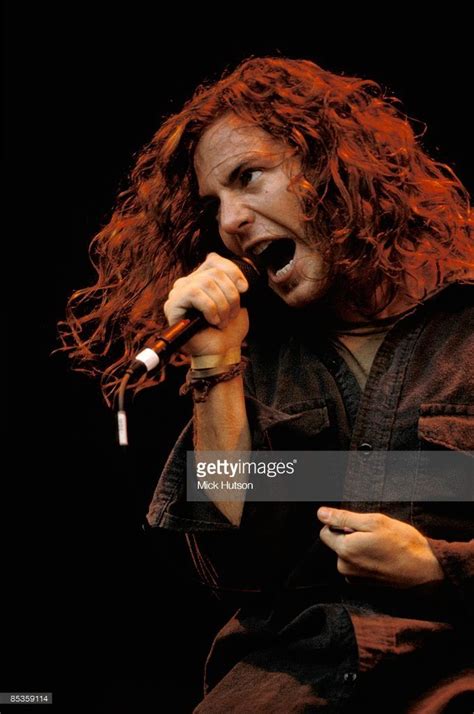 A Man With Long Red Hair Singing Into A Microphone