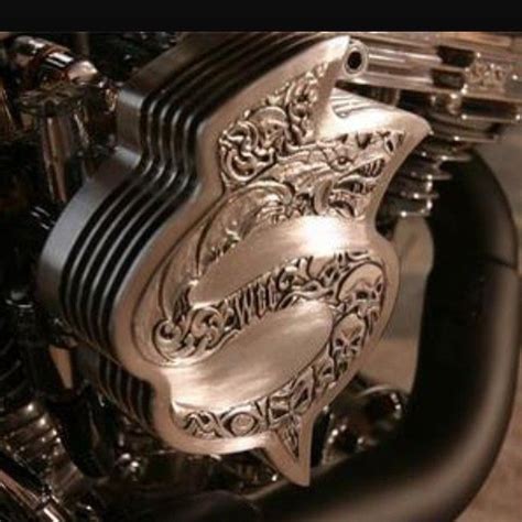 A Close Up Of A Motorcycle Engine With An Intricate Design On The Front