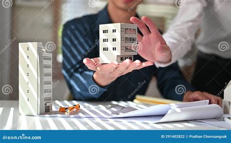 Two Architect Men Examining House Model While Working Construction
