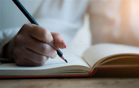 Woman Hand With Pencil Writing On Notebook Making Notes In Notebook