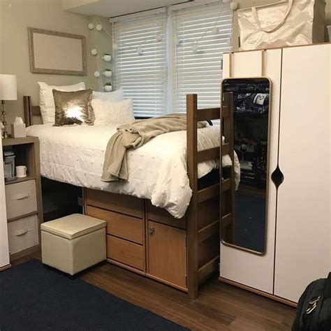 A Bed Sitting On Top Of A Wooden Floor Next To A Dresser Under A Window