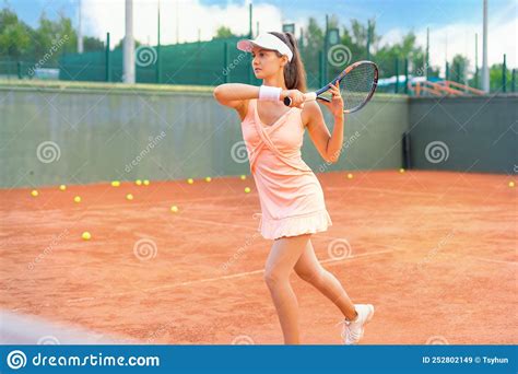 professional equipped female tennis player beating hard the tennis ball with racquet stock