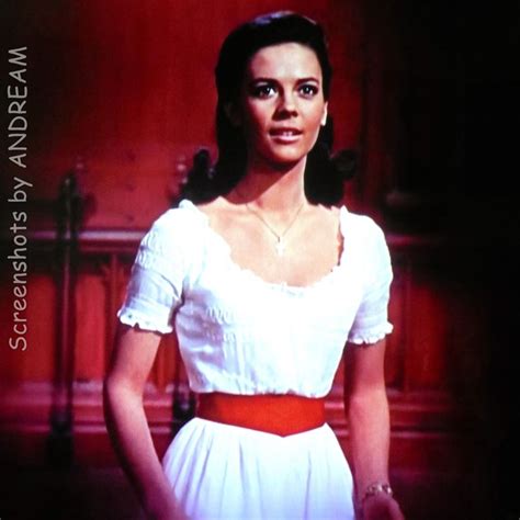 The Woman Is Wearing A White Dress And Red Belt