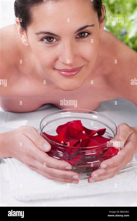Portrait Of A Woman Lying On A Massage Table Holding A Bowl Of Rose Petals Stock Photo Alamy