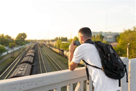 The Guy Standing On The Bridge Photographs The Railway Tracks At Sunset