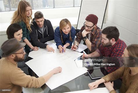 Young People Exchanging Ideas Around Table High Res Stock Photo Getty
