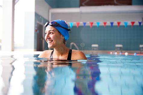 Female Swimmer Wearing Hat And Goggles Training In Swimming Pool Stock