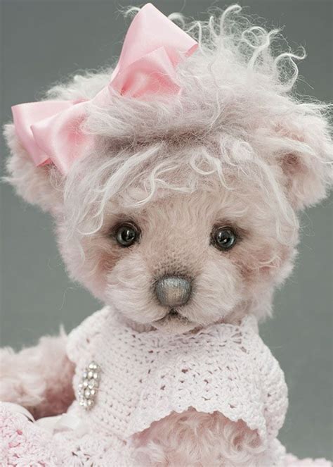 A White Teddy Bear Wearing A Pink Bow And Sweater With Pearls On Its Head