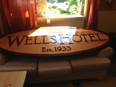 A Wooden Hotel Sign Sitting On Top Of A Couch In Front Of A Windowsill