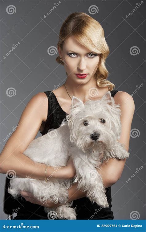 Blondes Mädchen Der Alten Art Und Weise Hat Sie Einen Hund In Ihren Armen Stockfoto Bild Von