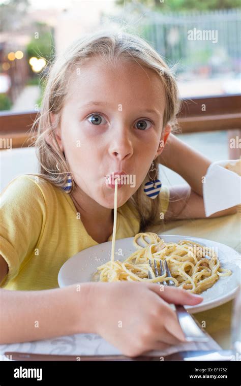 Adorable Little Girl Eating Spaghetti In Outdoors Restaraunt Stock