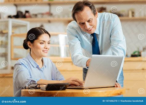Reliable Friendly Boss Standing And Helping His Colleague Stock Photo