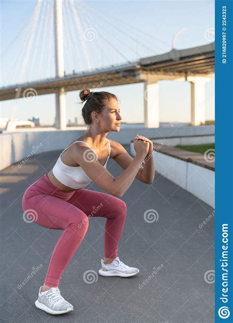 sporty woman in trendy sportswear doing sit up exercises outdoors slim squatting girl working