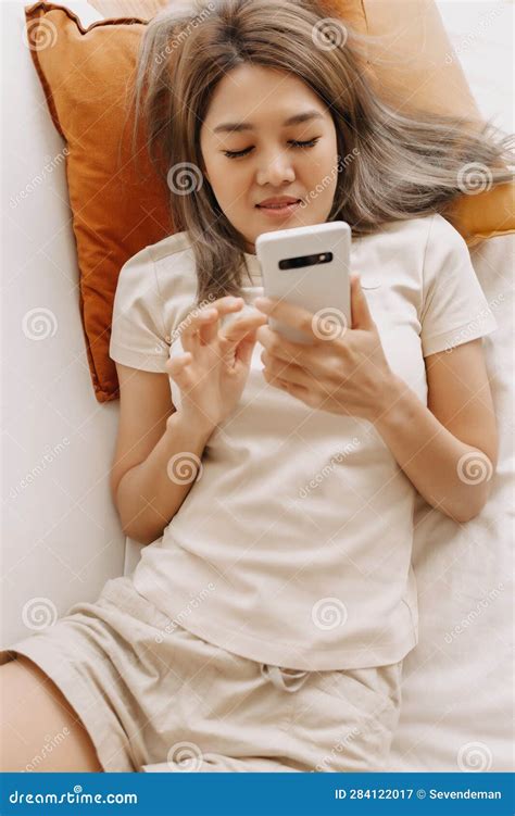 Happy Woman Rest And Lie On The Sofa Using Smartphone In The Living Room Stock Image Image Of