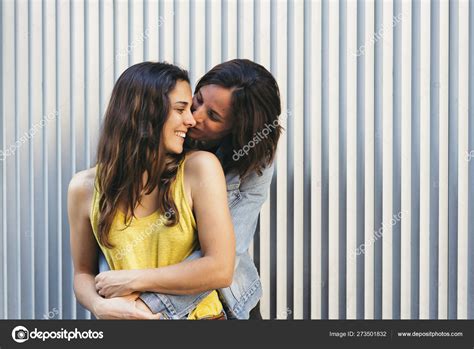 affectionate woman kissing her happy girlfriend smiling same sex relationship concept stock