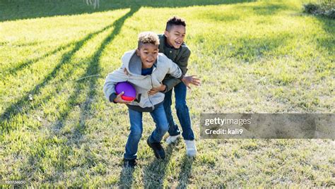 Two Boys Playing Football In Back Yard High Res Stock Photo Getty Images