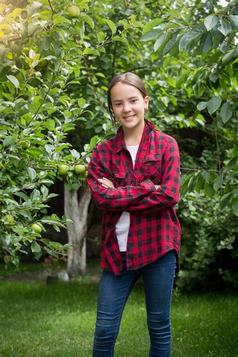 Teenage Girl In Red Checkered Shirt Posing At Apple Garden Stock Image