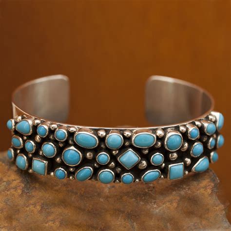 A Silver Cuff With Turquoise Stones On It