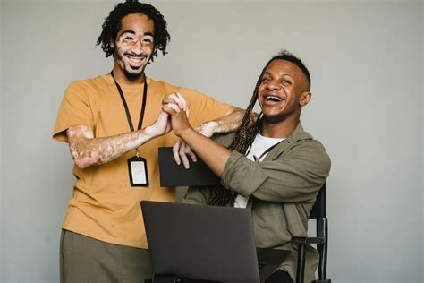 Smiling black coworkers holding hands in studio · Free Stock Photo