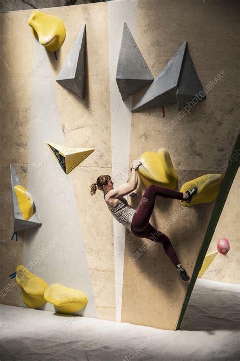 Young Female Rock Climber Hanging From Climbing Wall Stock Image