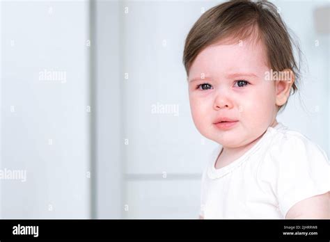 Portrait Unhappy Crying Baby Child Sitting On Highchair On Kitchen At