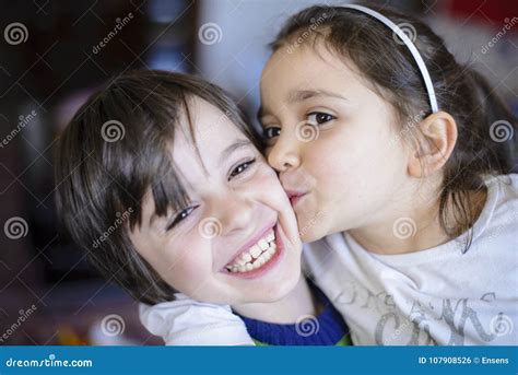 Beso De Los Hermanos De Los Niños En La Mejilla Foto De Archivo