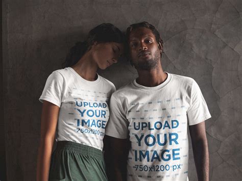placeit posing interracial couple wearing t shirts mockup against a gray wall