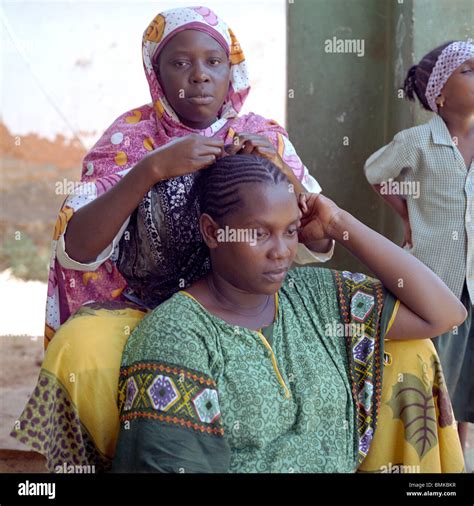 African Women In A Traditional Kenyan Village One Woman Braiding Stock