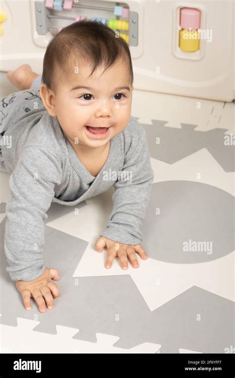 Six Month Old Baby Boy Portrait Smiling Looking Up To Side On Stomach