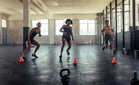 Group Of Young People Running In Crossfit Gym Young Man And Women In
