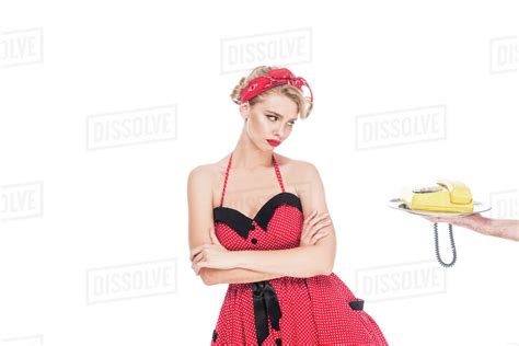 upset pin up woman looking at retro telephone on serving tray in male hand isolated on white