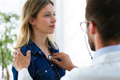 Handsome Young Male Doctor Checking Beautiful Young Woman Patient