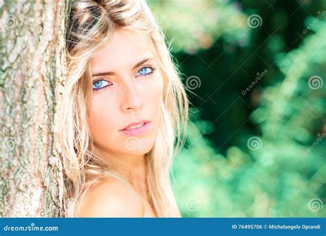 Portrait Of Beautiful Blond Girl With Blue Eyes In Nature Stock Photo