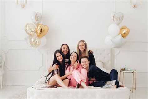 Group Of Happy Girl Friends Laughing Posing On Bed Enjoying Pajamas