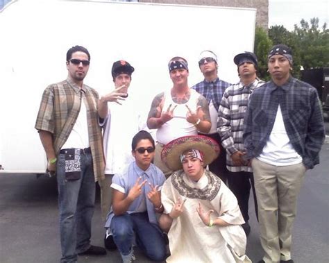 A Group Of Men Standing Next To Each Other In Front Of A White Trailer