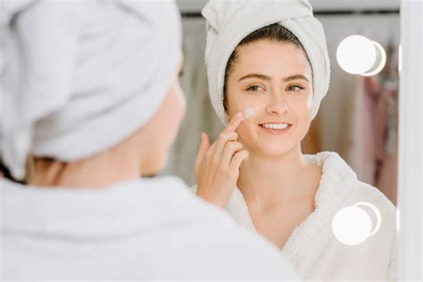 Premium Photo Face Cream Woman In Bathrobe With A Towel On Her Head