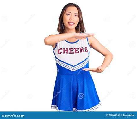 Young Beautiful Chinese Girl Wearing Cheerleader Uniform Gesturing With