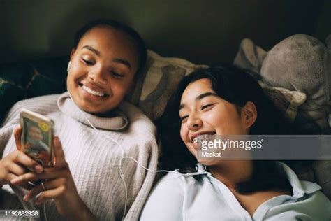 two teenage girls on the phone lying on bed photos and premium high res pictures getty images