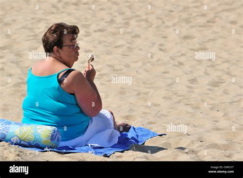 Obese Woman In Summer Eating Ice Cream On Beach Along The North Sea Coast At Koksijde Coxyde