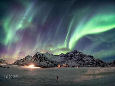 Confronted With Light Man On Snowy With Aurora Borealis Over Mountain